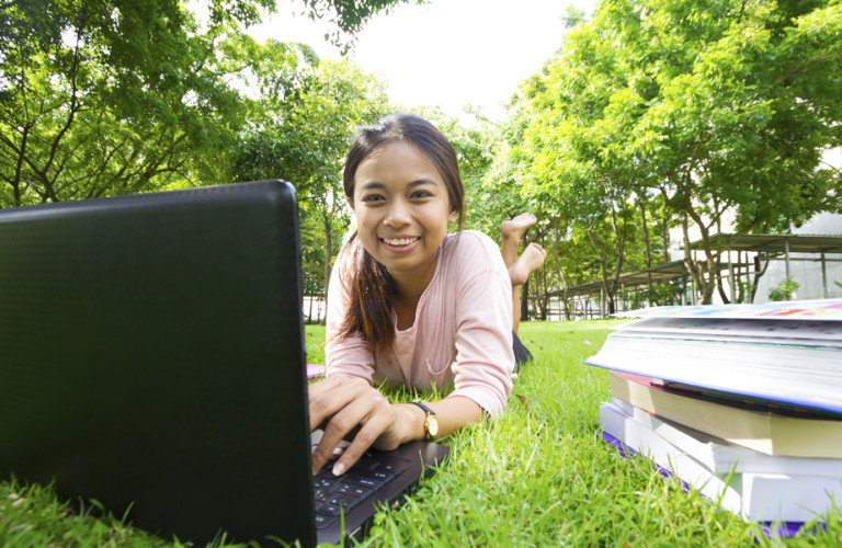 A girl studying outside during the summer with books