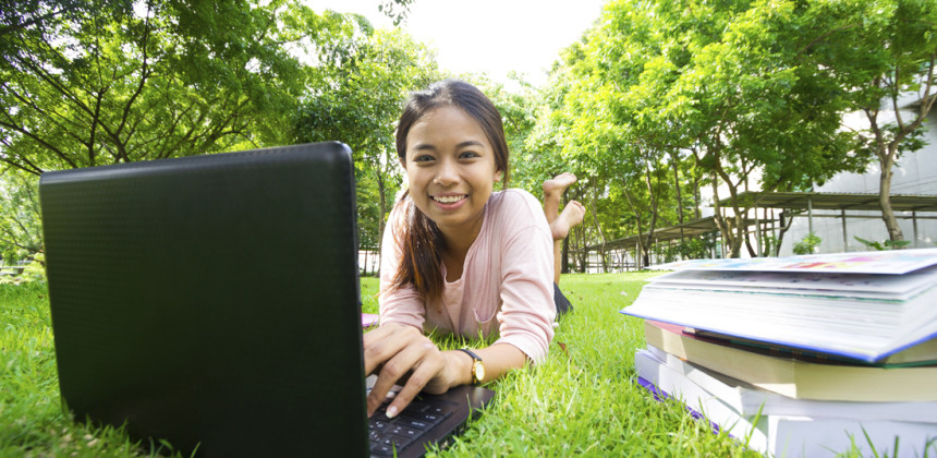 A girl studying outside during the summer with books