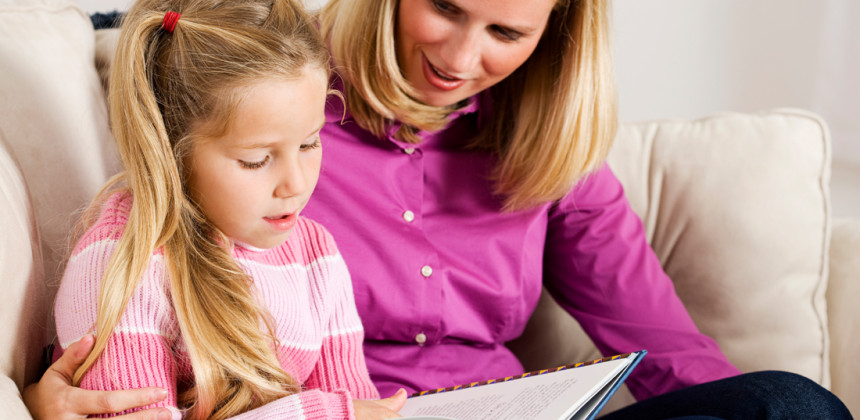 A mother reading along with her daughter