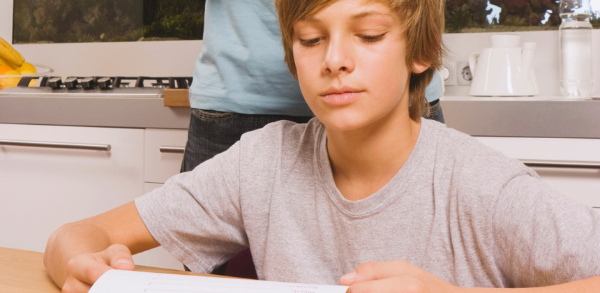 Teenager looking at his report on the table