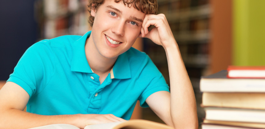 Teenage boy reading at the library