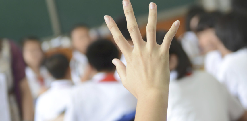 Student raising their hand in class