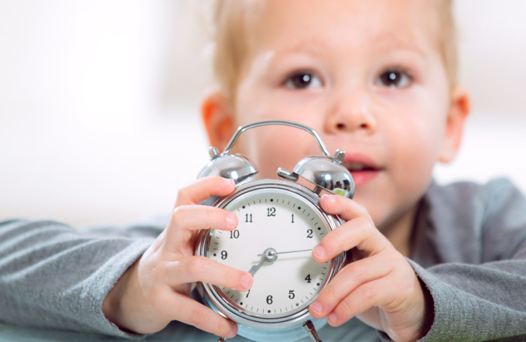 Young boy holding an alarm