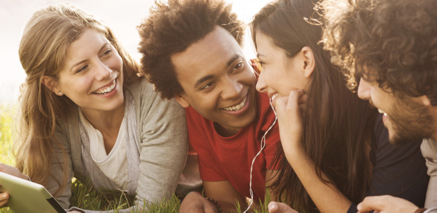 Teenagers lying in the grass talking