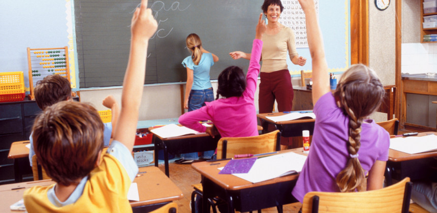 A child confidently writing on the classroom chalkboard