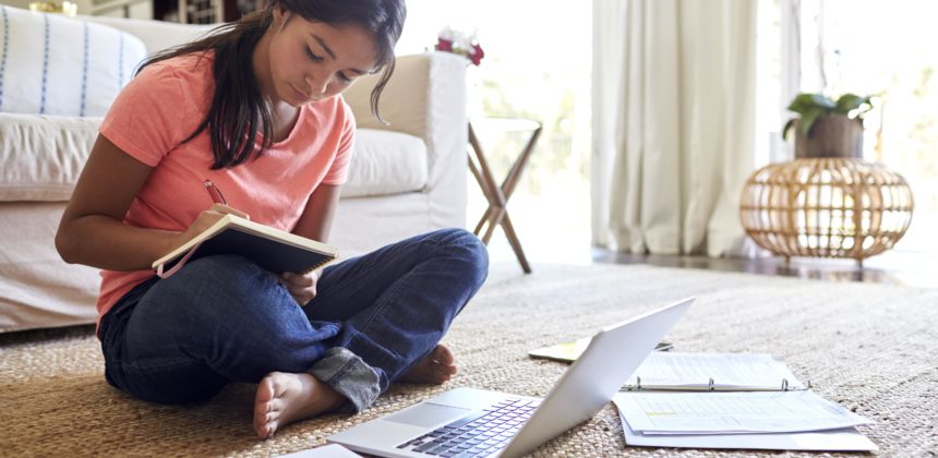 A young female student working on homework in her room.