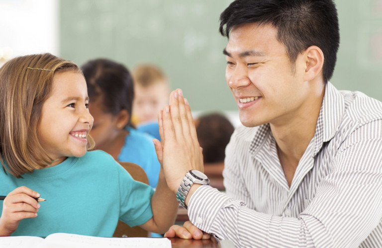 Teach and student high fiving in class