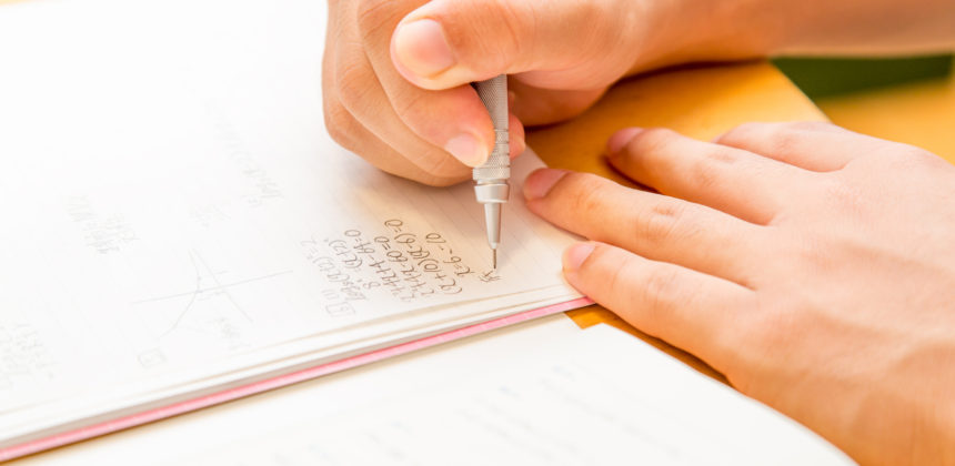 Close up of hands writing study notes