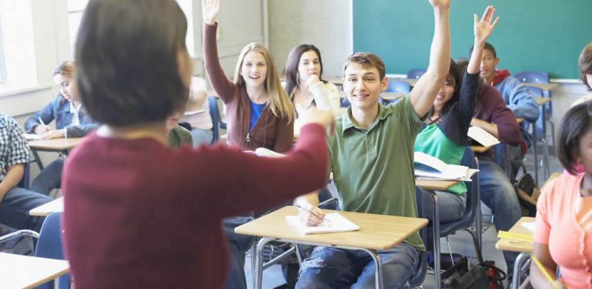 Students in class eagerly raising their hands