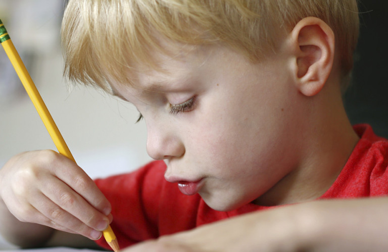 Young boy writing his homework