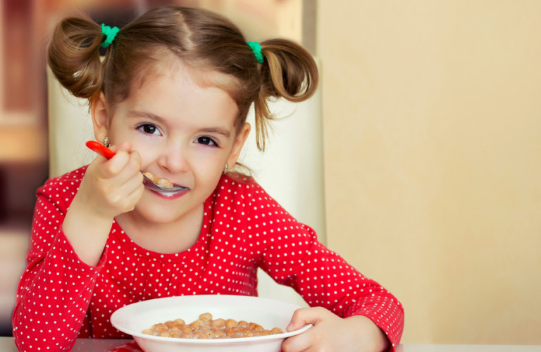 A little girl eating cereal for breakfast