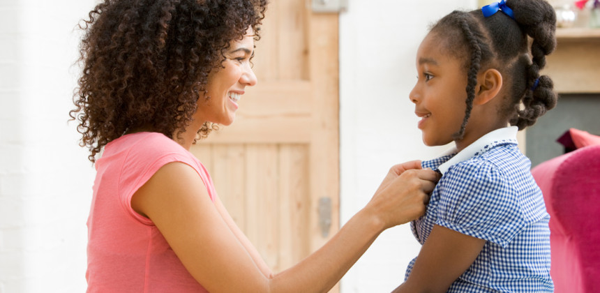 Young girl preparing to go back to school with her mother