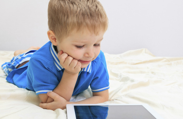 A toddler reading an ipad
