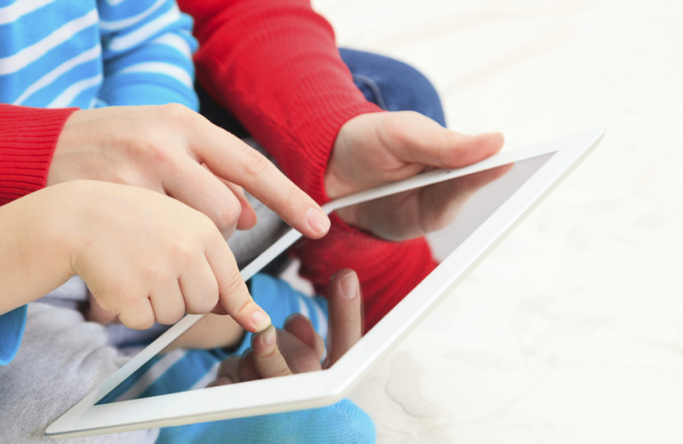A young child and parent using a tablet