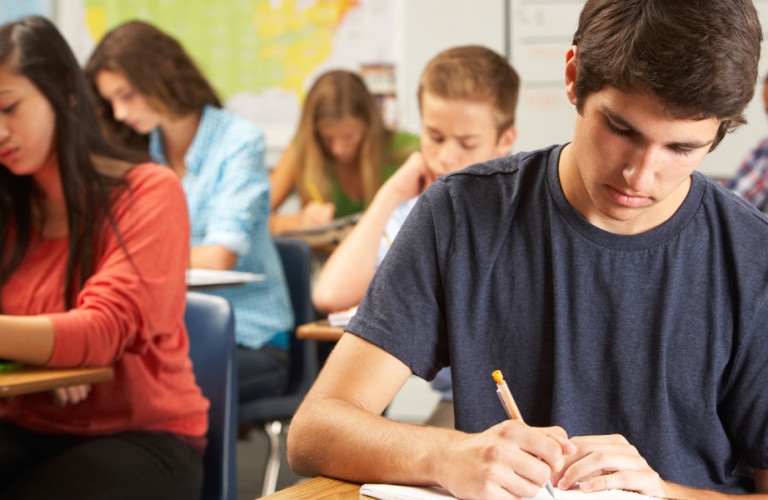 Student writing an exam in a classroom