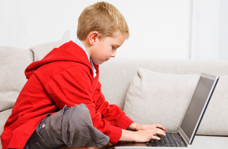 Young boy using a computer in his living room