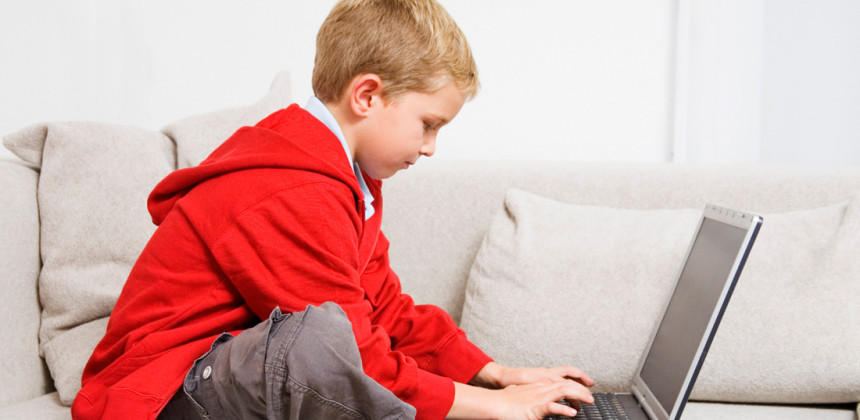 Young boy using a computer in his living room