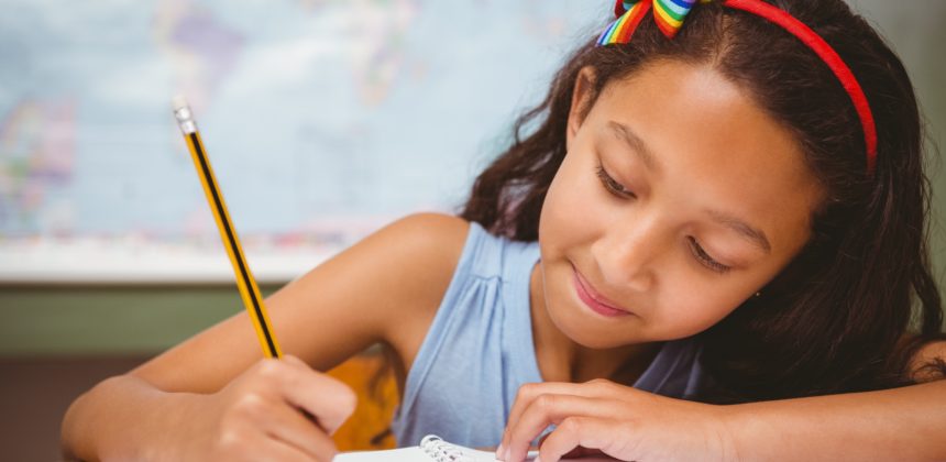 Little girl writing in book