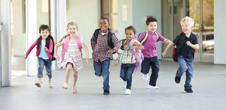 Group Of Elementary Age Schoolchildren Running Outside