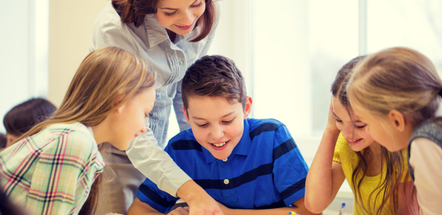 teacher helping students studying in the classroom