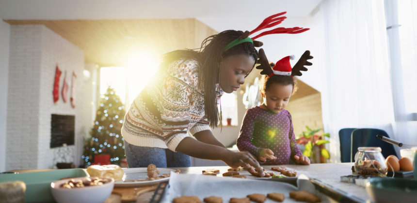 Parent and child baking holiday treats, while wearing festive outfits.