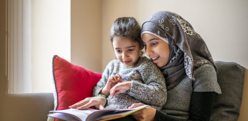 Big sister reads stories to her little sister