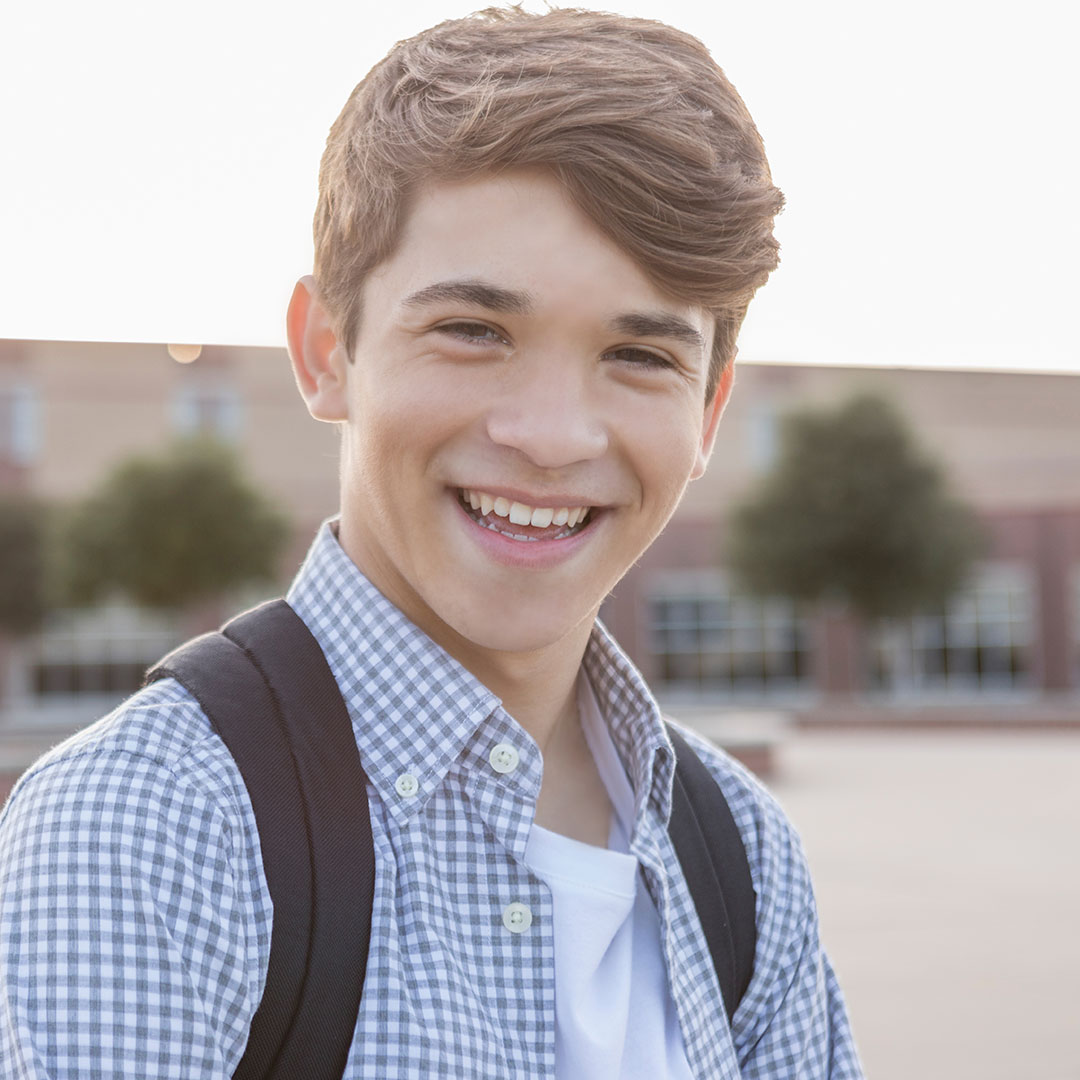 A male student smiling in front of his tutoring centre.