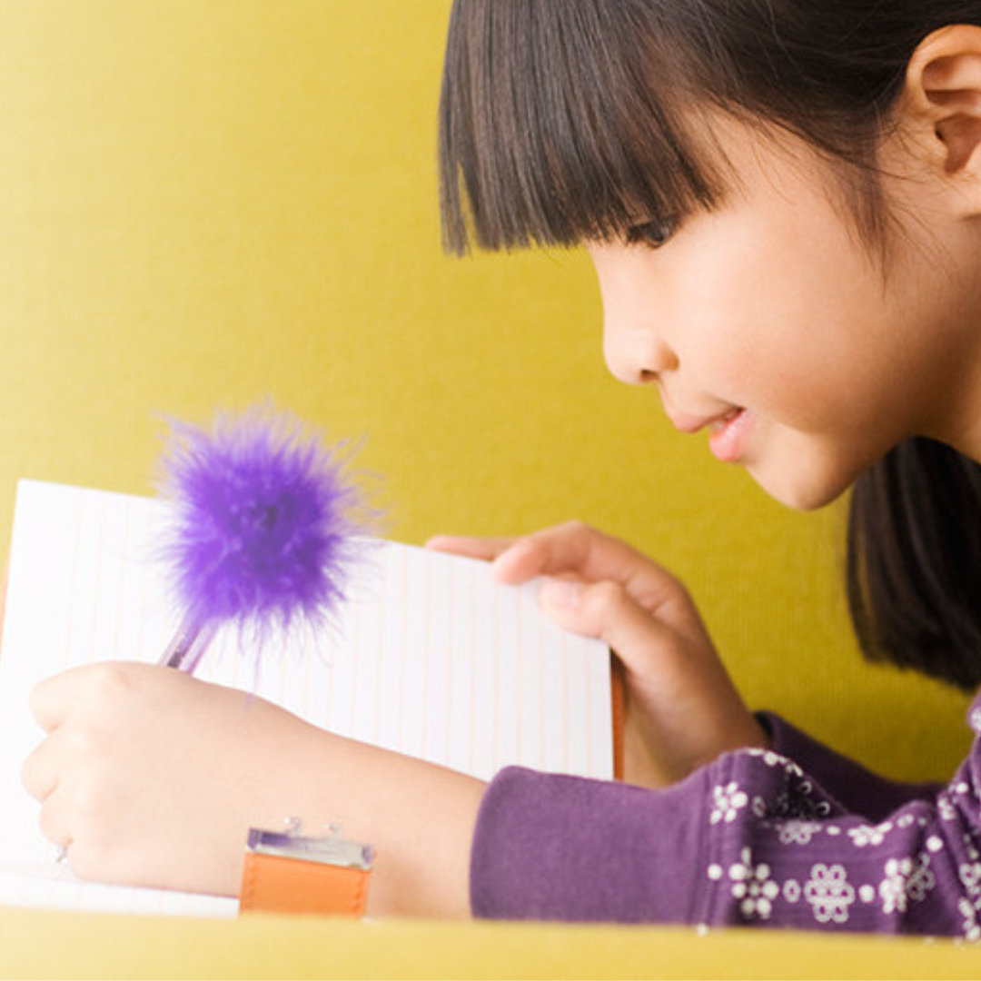 A student is writing lessons while learning a new language in her program workbook.