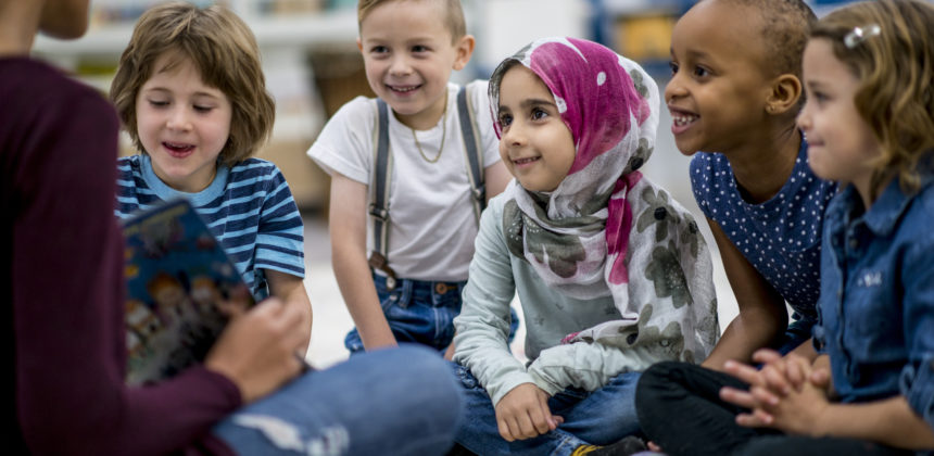 Children listen intently as their teacher reads to them